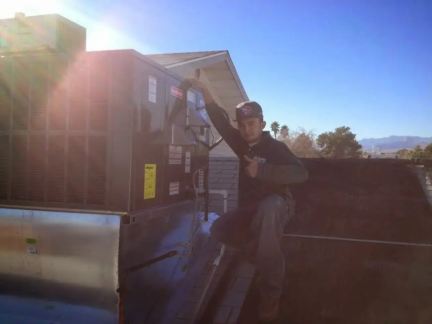 HVAC technician performing Boiler Repair on a rooftop unit in Coralville